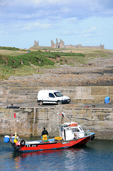 Fishing Boat in Harbour, with Dunstanburgh Castle in the Distance