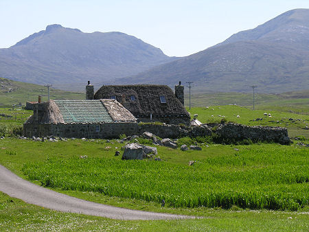 Thatched Croft House with the Mountains of South Uist in the Background