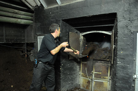Feeding the Furnace at Laphroaig with Peat