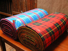 Story of a Tartan.  The tartan on the left is the South Australian Pipes & Drums Tartan.  Here it is after weaving  at Andrew Elliot Ltd in Selkirk